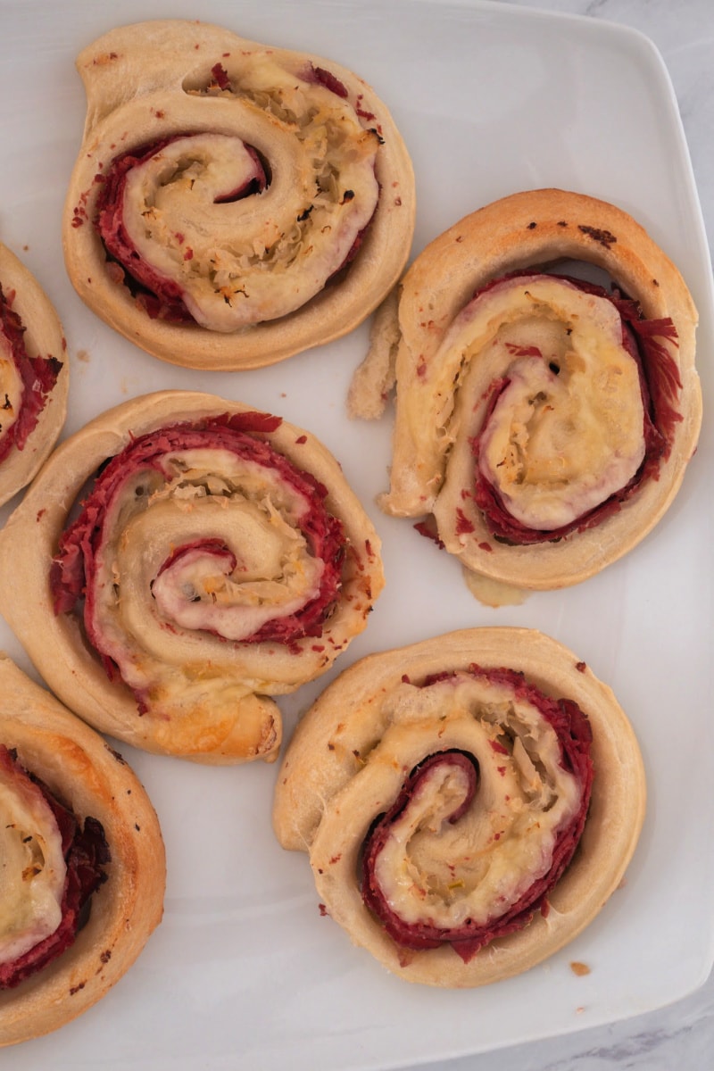 These Reuben Pizza Rolls are a quick and easy Irish inspired recipe in which corned beef, Swiss cheese and sauerkraut are rolled up inside pizza dough for a St. Patrick's Day twist! This simple five ingredient recipe is ready to eat in less than 30 minutes. #reuben #pizzaroll