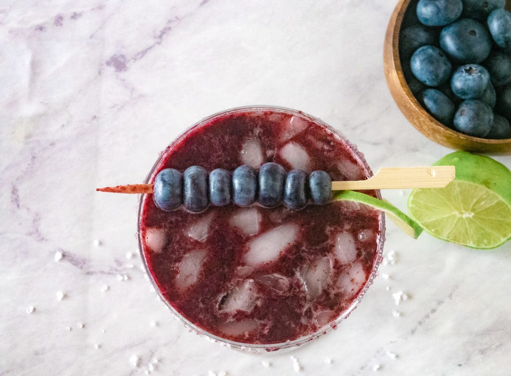 looking down on a glass full of blueberry margarita
