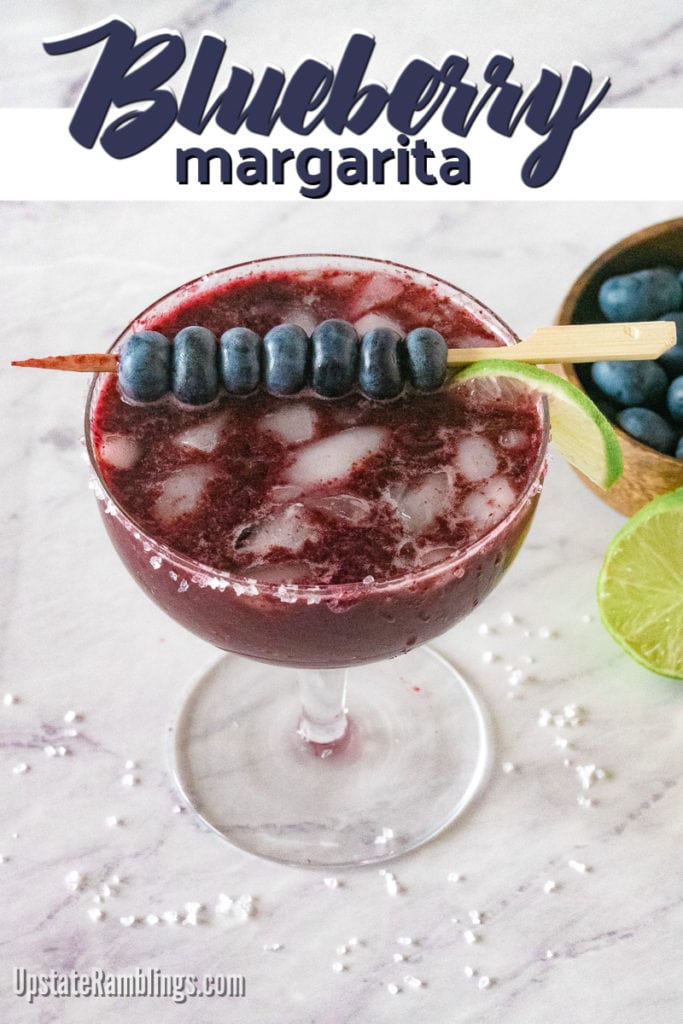 Blueberry margarita in a glass garnished with blueberries and lime