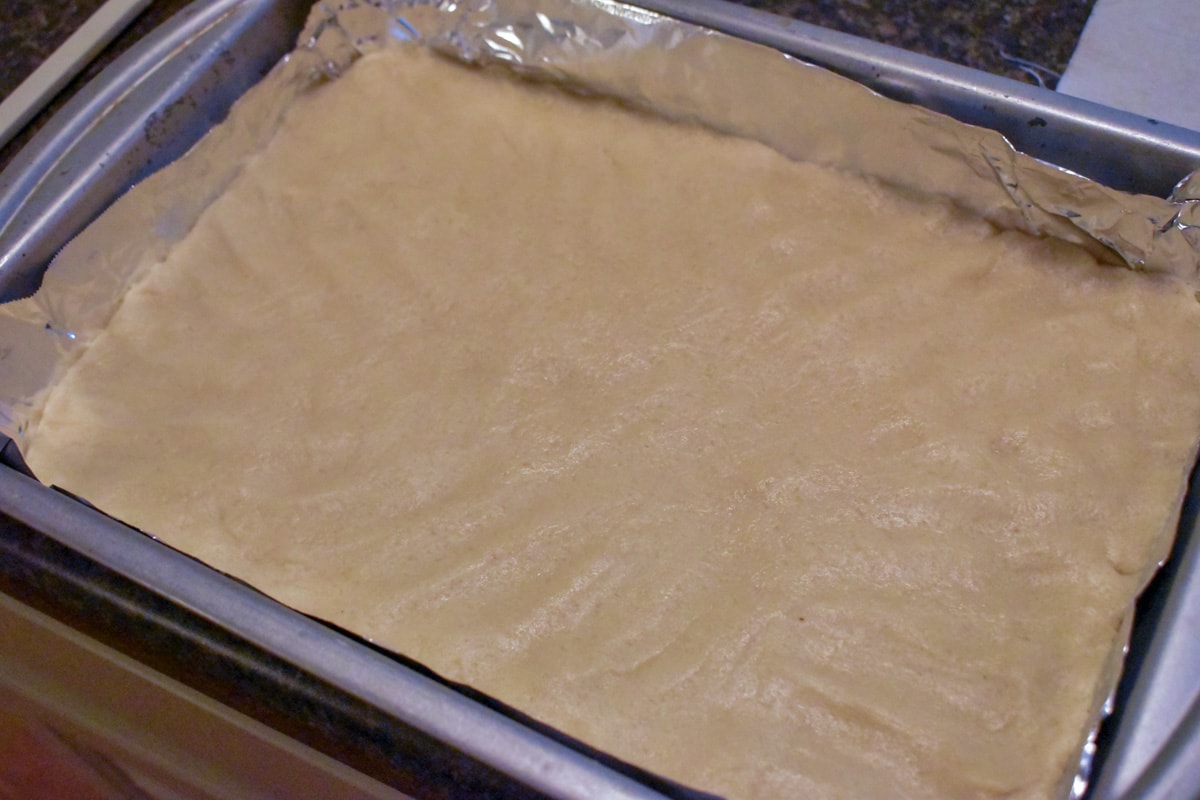 Dough for sugar cookie bars pressed into a baking pan