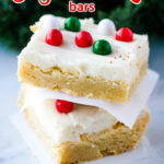 sugar cookie bars stacked in front of a holiday greens