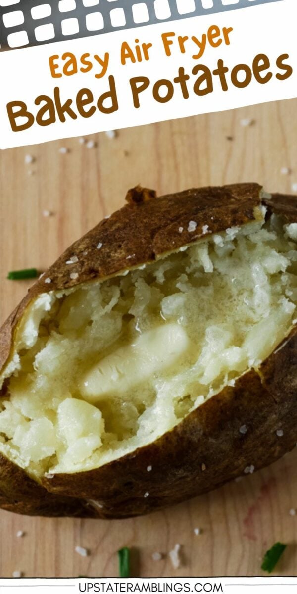 Close-up of a baked potato split open with a pat of butter melting inside, set on a wooden surface with sprinkled salt and chopped chives. "Easy Air Fryer Baked Potatoes" text is visible at the top, showcasing the perfect way to make air fryer baked potatoes.