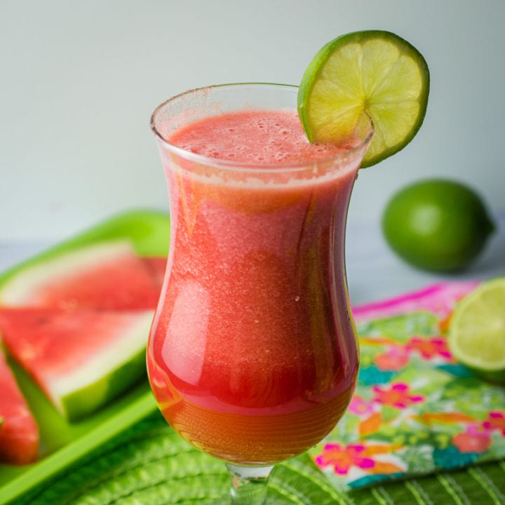 glass of vodka watermelon cocktail garnished with lime