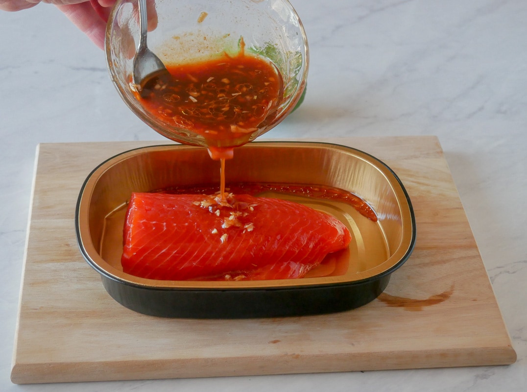 pouring marinade over the salmon fillet