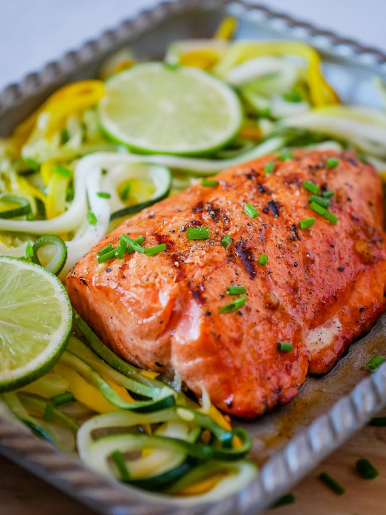 spicy grilled salmon on a platter with lime