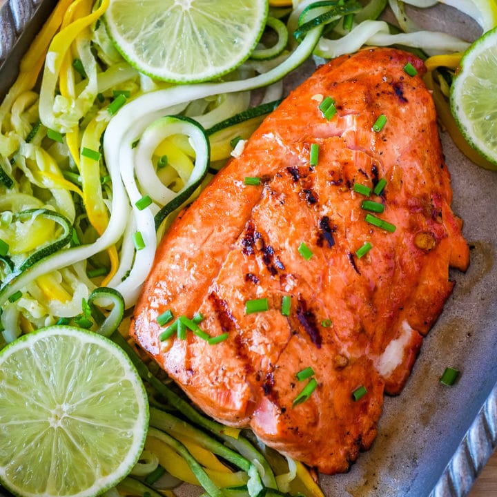 grilled salmon on a platter with lime and summer squash