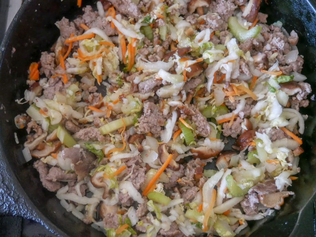 cooking the pork and veggies for homemade egg rolls