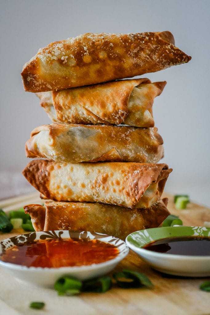 stack of air fryer egg rolls on a wooden cutting board