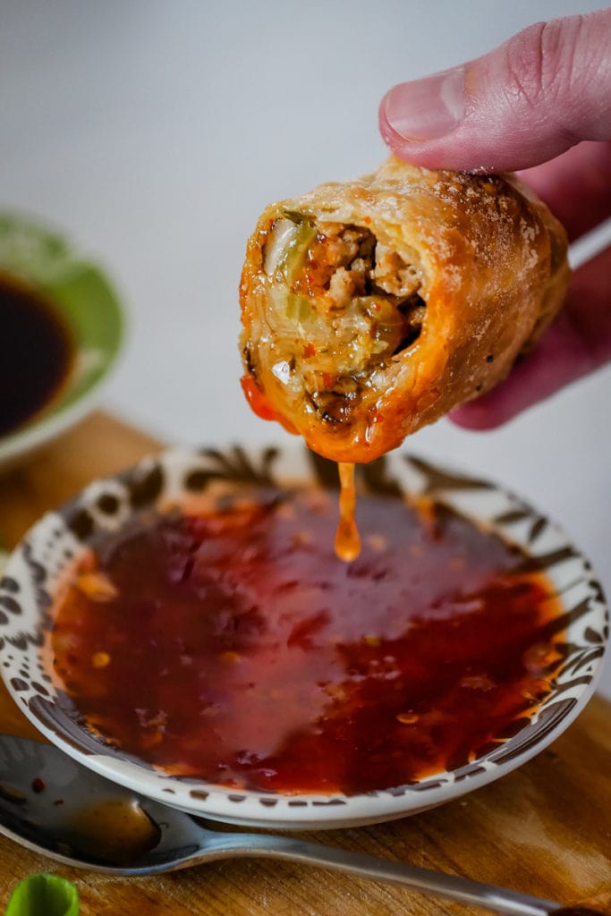 Chili sauce dripping off a homemade air fryer egg roll