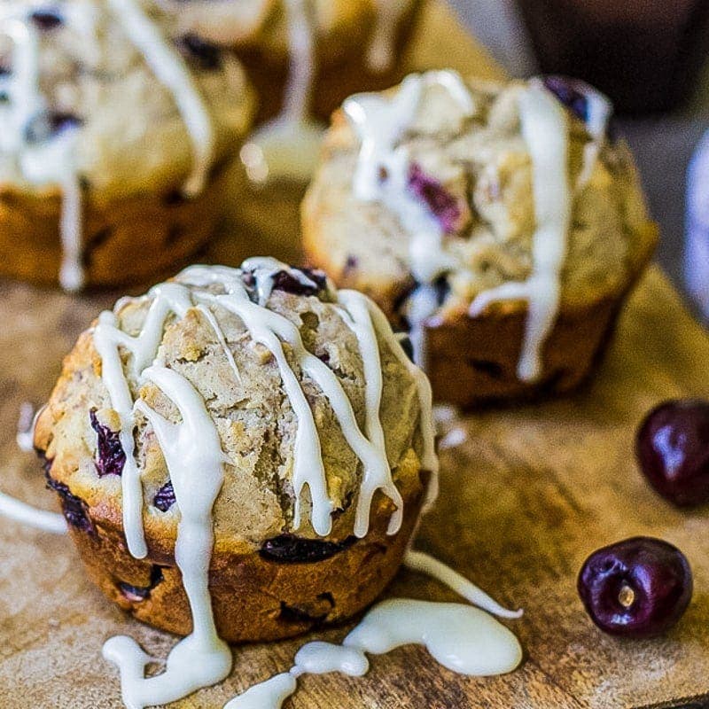 fresh cherry muffins on a wooden cutting board