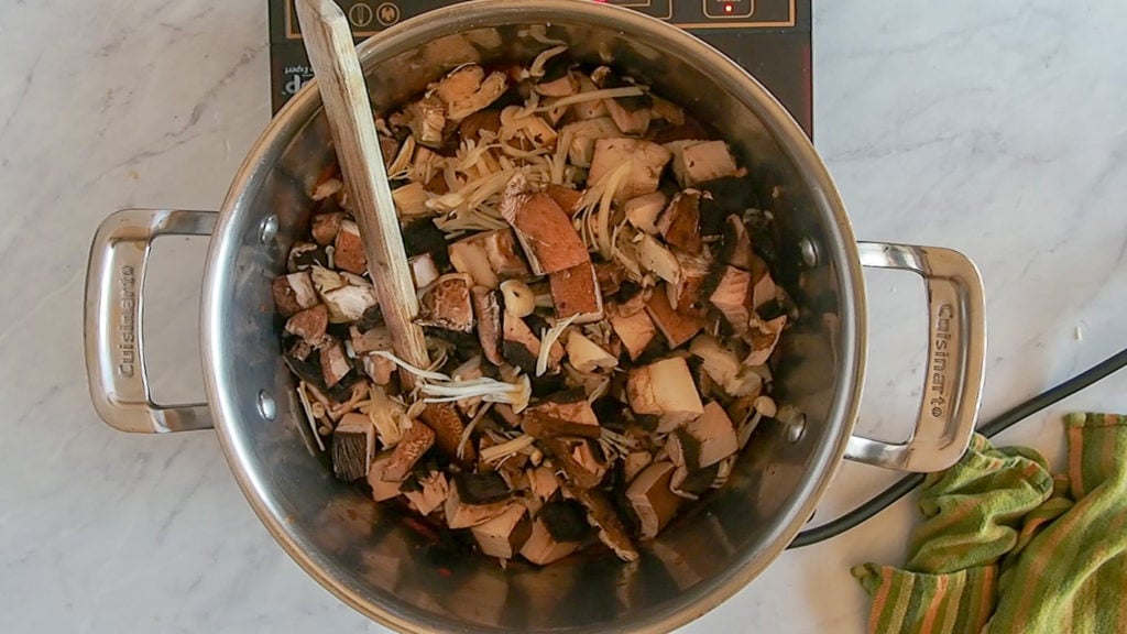 adding the mushrooms to the mushrooms stew