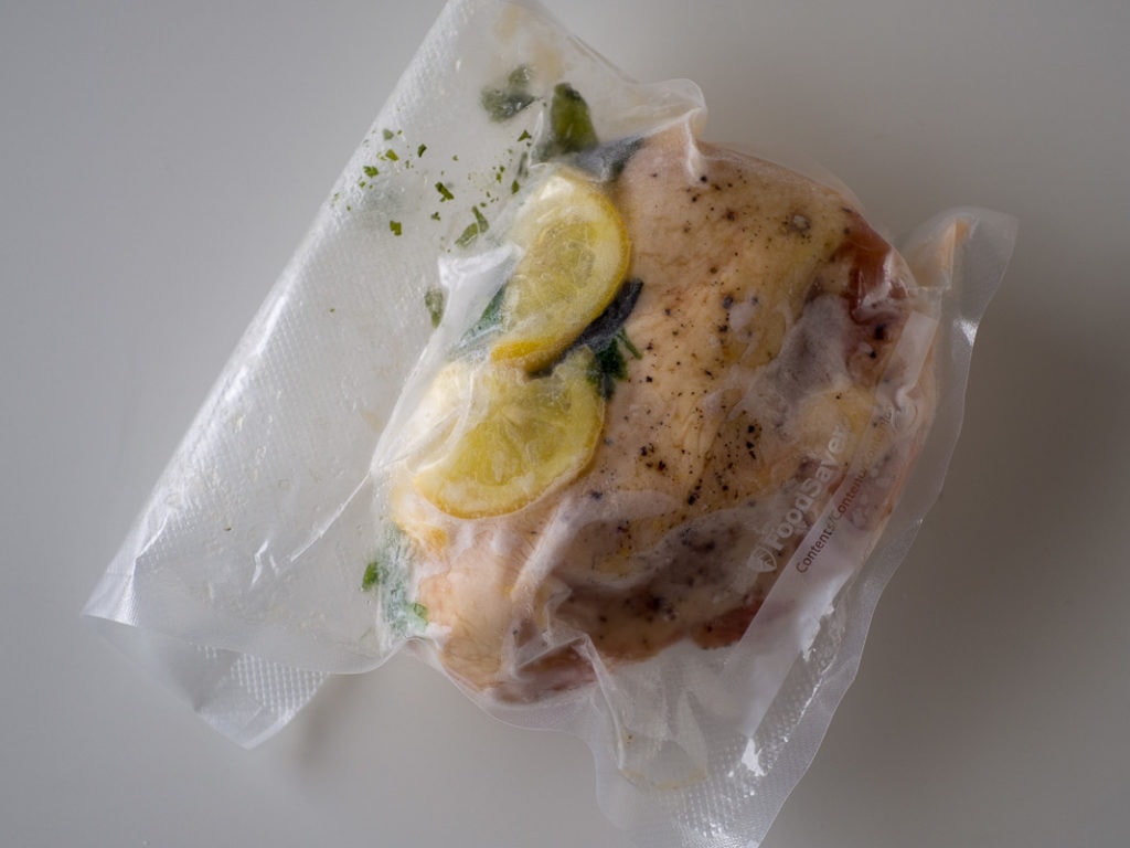 vacuum bag with chicken breast and lemon and herbs