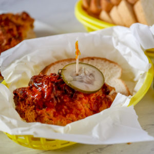 Nashville hot chicken in a basket with a pickle