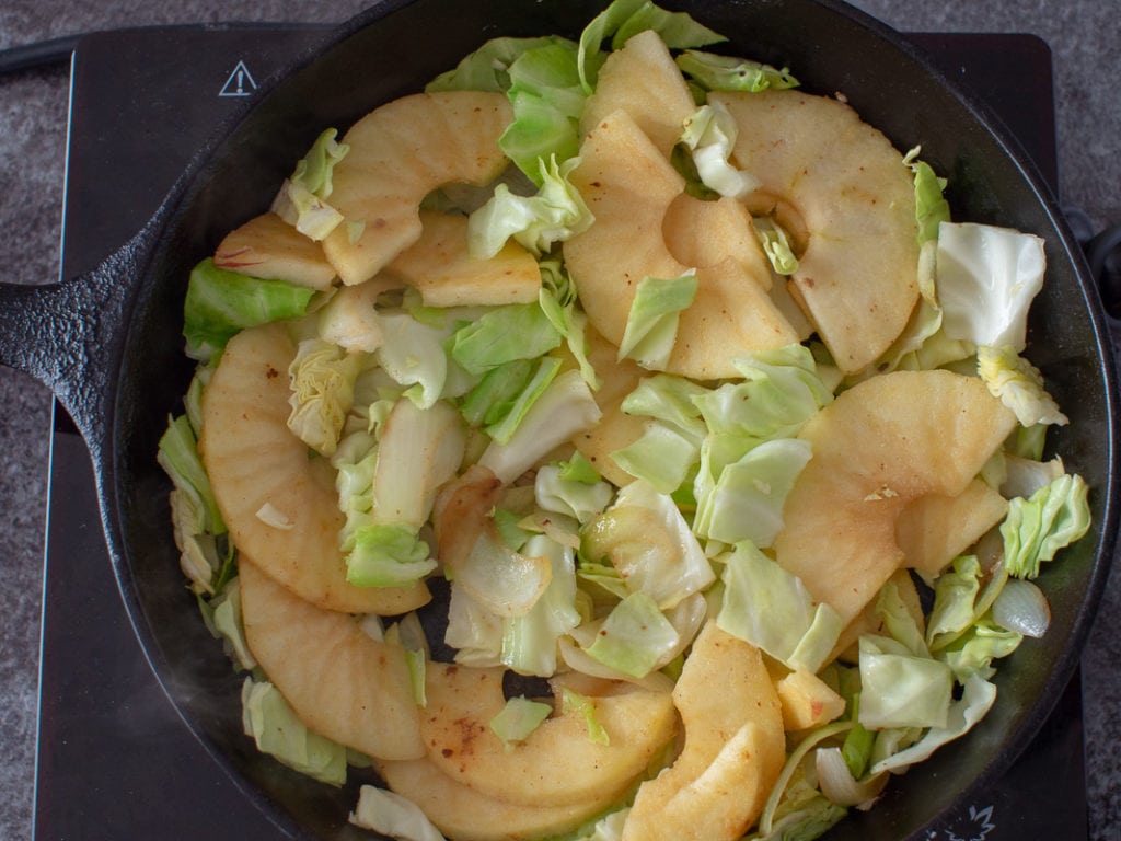 sauteing the apples and cabbage in the skillet