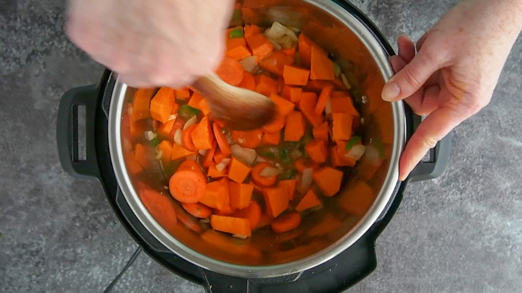 deglazing the instant pot while making chicken stew with squash