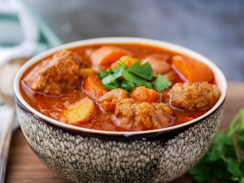 Instant Pot meatball soup in a bowl with meatballs, carrots and potatoes