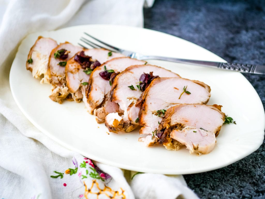 turkey breast on a plate with cranberry pan sauce