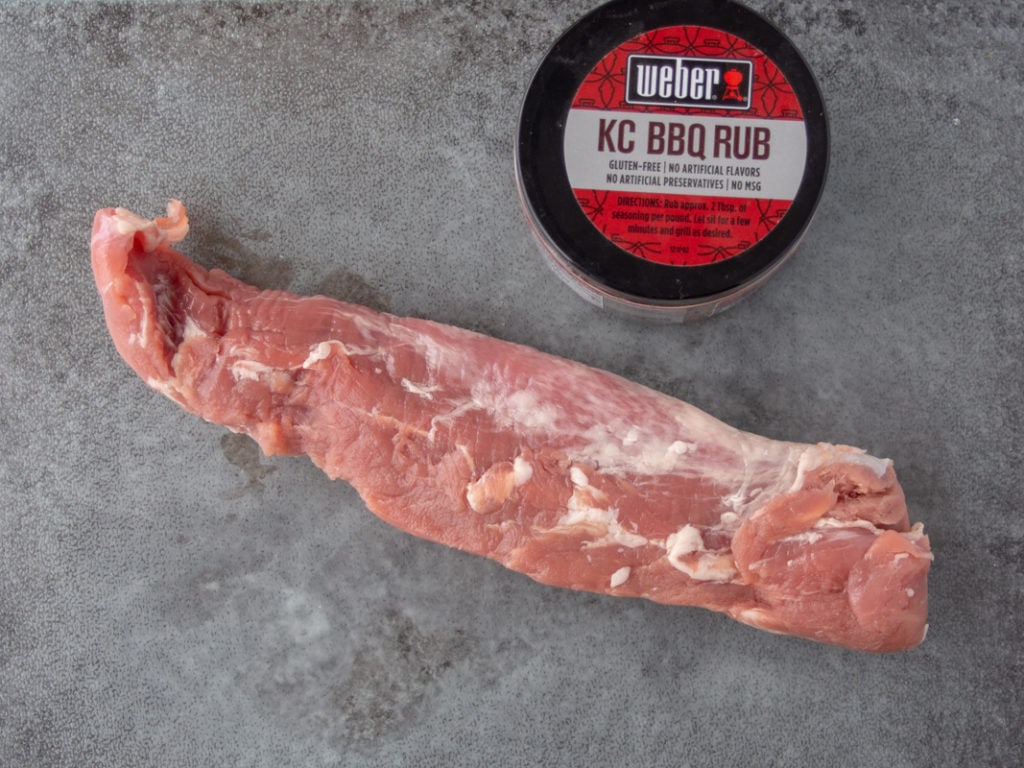 raw pork tenderloin on cutting board with spice rub