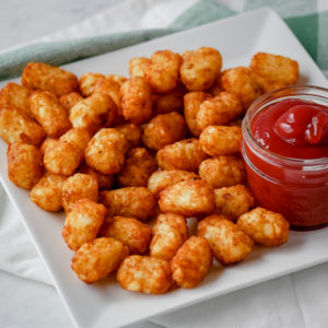 tater tots on a plate with dipping sauce