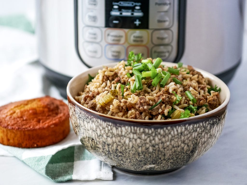 bowl of dirty rice in front of an instant pot