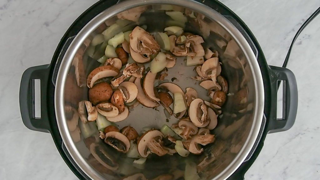 cooking mushrooms and onions for fettuccine alfredo