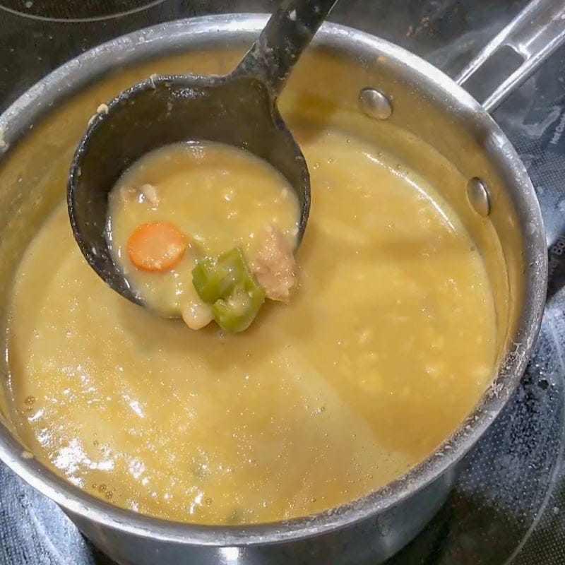 sauce pan with salmon chowder being ladled out