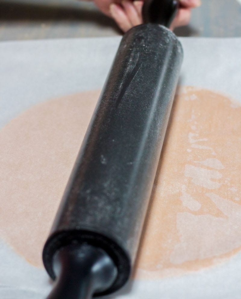 rolling the dough between sheets of parchment paper
