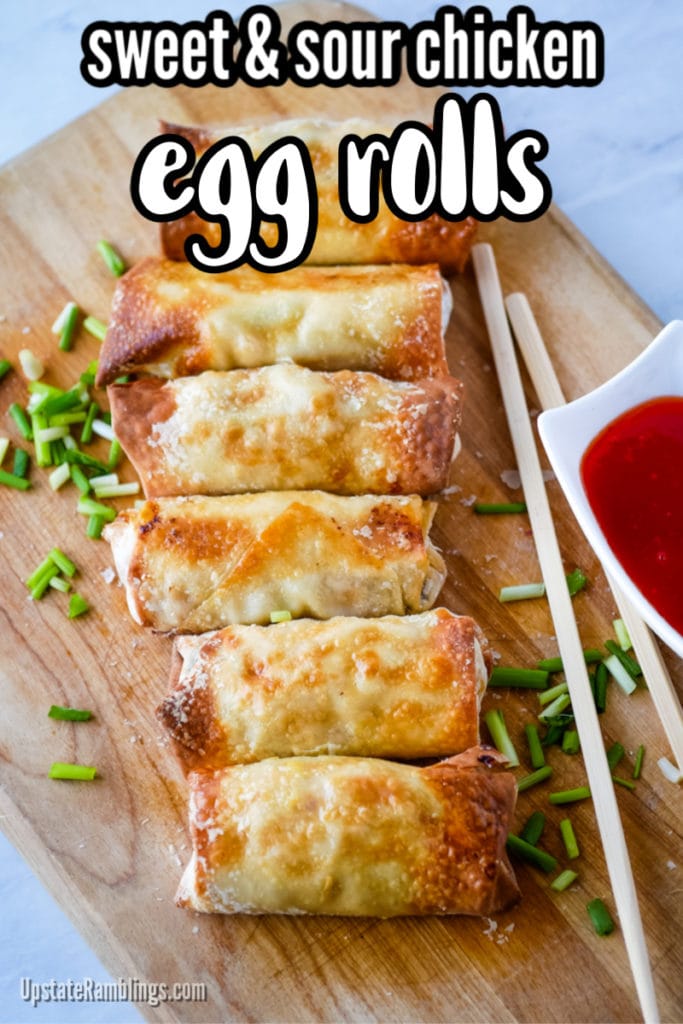 air fryer sweet and sour chicken egg rolls on a wooden cutting board with green onions and chopsticks