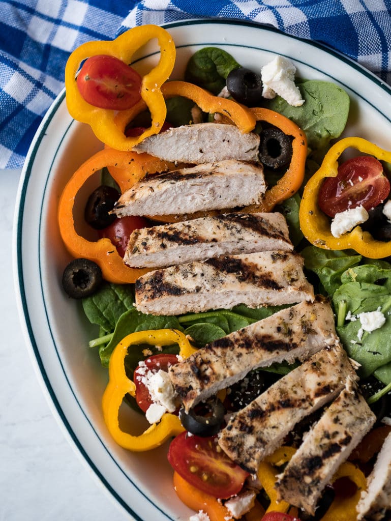 grilled chicken on salad greens in a bowl