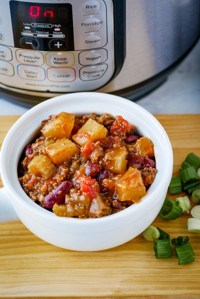 bowl of pineapple chili in front of a pressure cooker