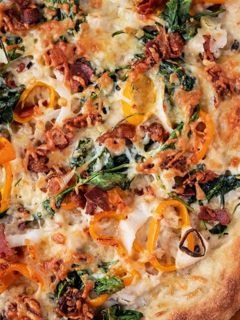 closeup of turkey pizza showing spinach and orange pepperes