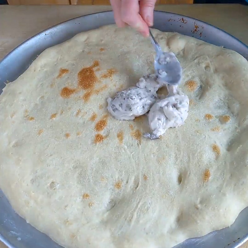 spreading cream of mushroom soup on a pizza for sauce