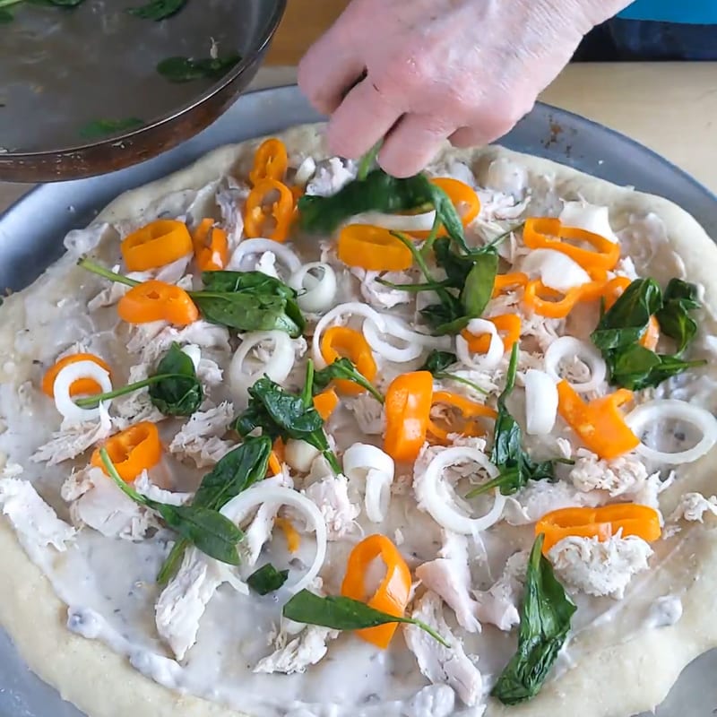 adding toppings to a turkey pizza