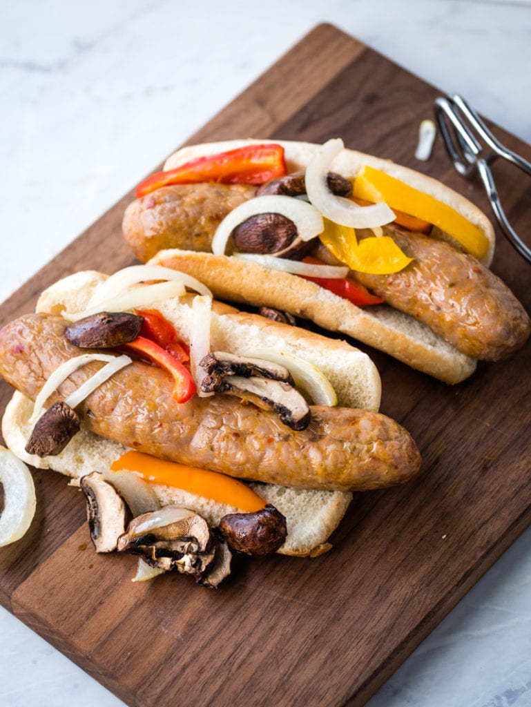 top view of Italian sausage with vegetables on a wooden cutting board