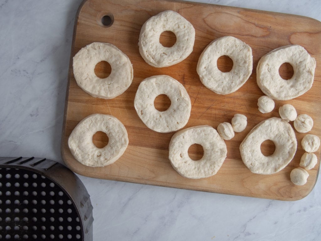 biscuit donuts on a cutting board ready for air frying