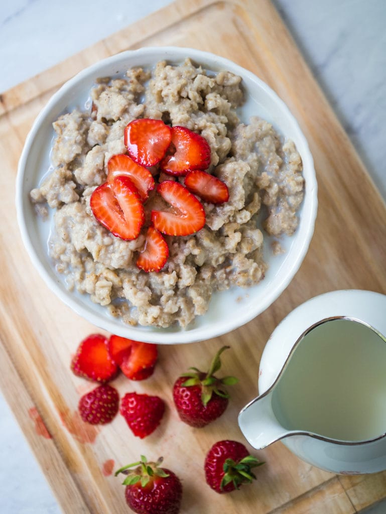 top view of oatmeal with milk and strawberries