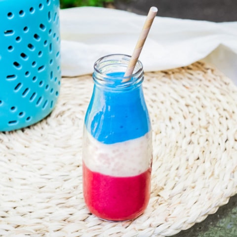 patriotic smoothie in a glass jar with a straw
