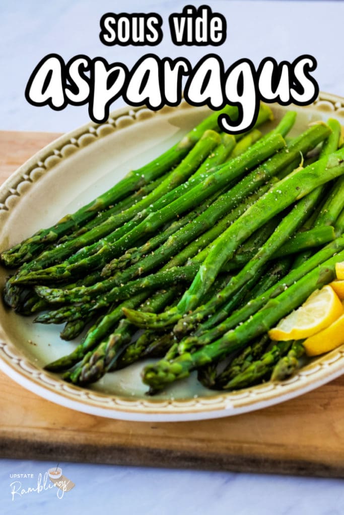 platter of cooked asparagus with lemon in the foreground