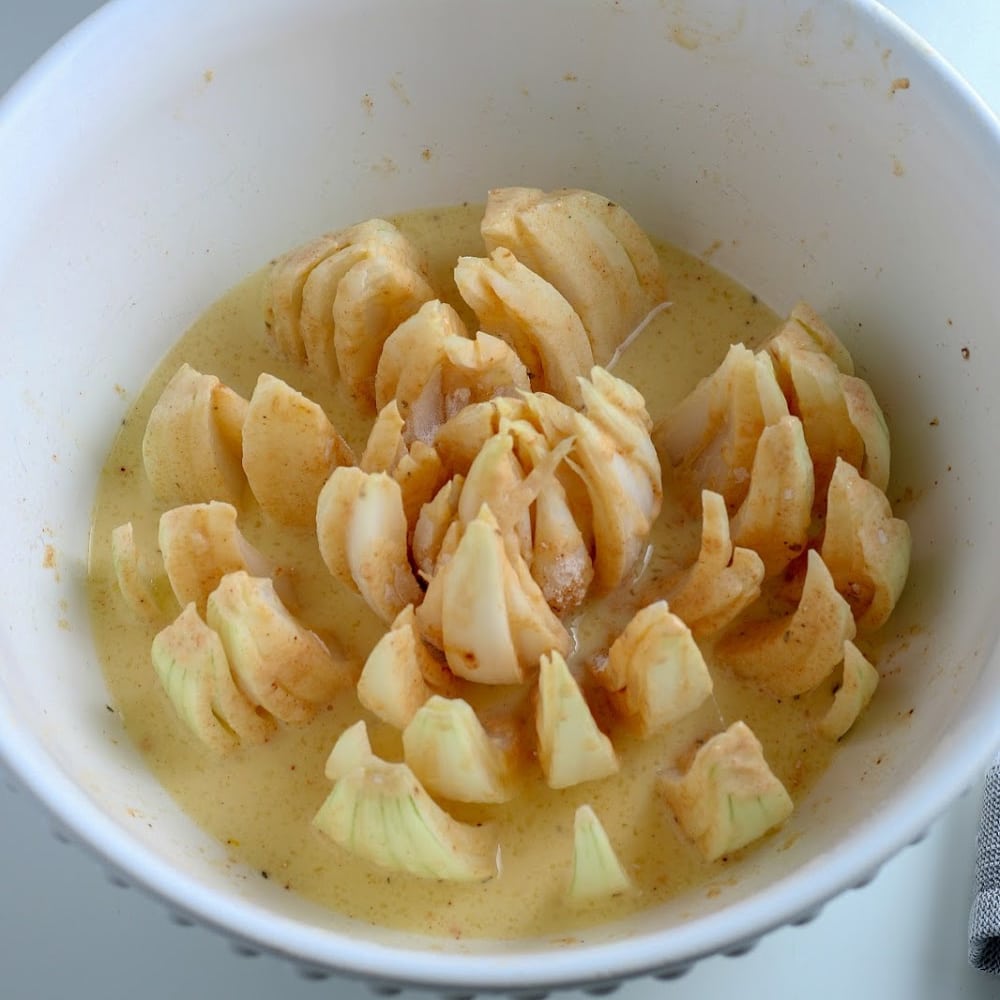 An air fryer filled with apples in a sauce.