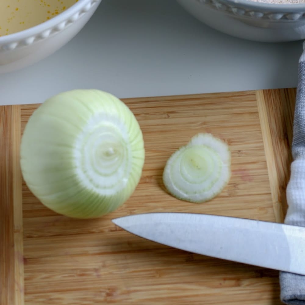 An onion next to a knife.