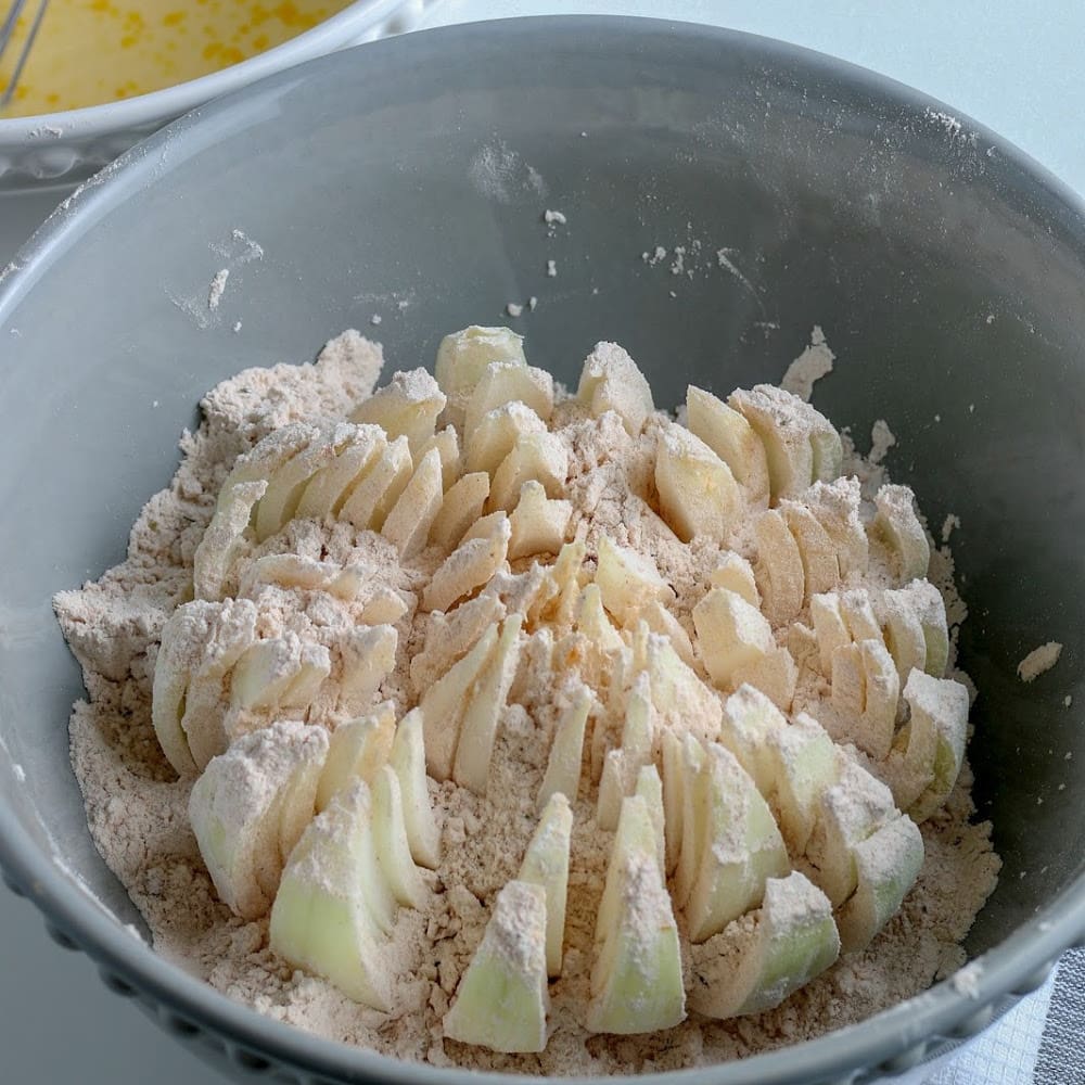 A bowl filled with a mixture of flour, apples, and an air fryer.