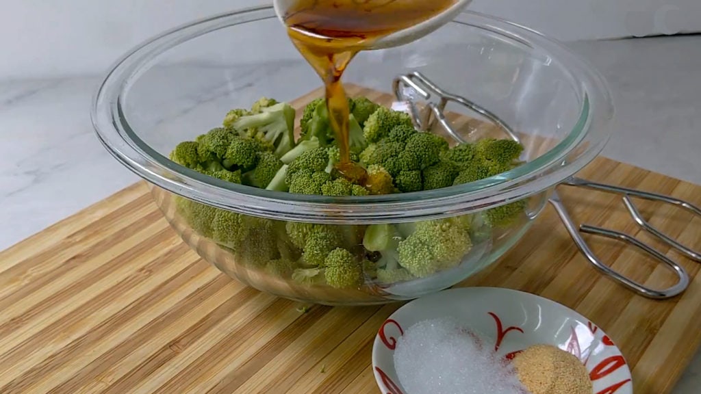 adding sesame oil to the broccoli