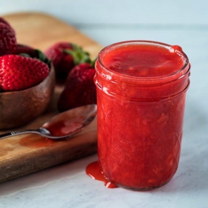 strawberry sauce with a spoon next to the jar