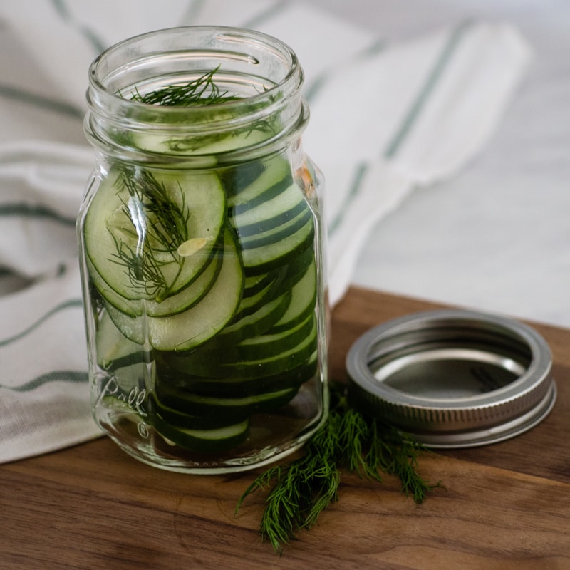 filling the jar with cucumbers and dill