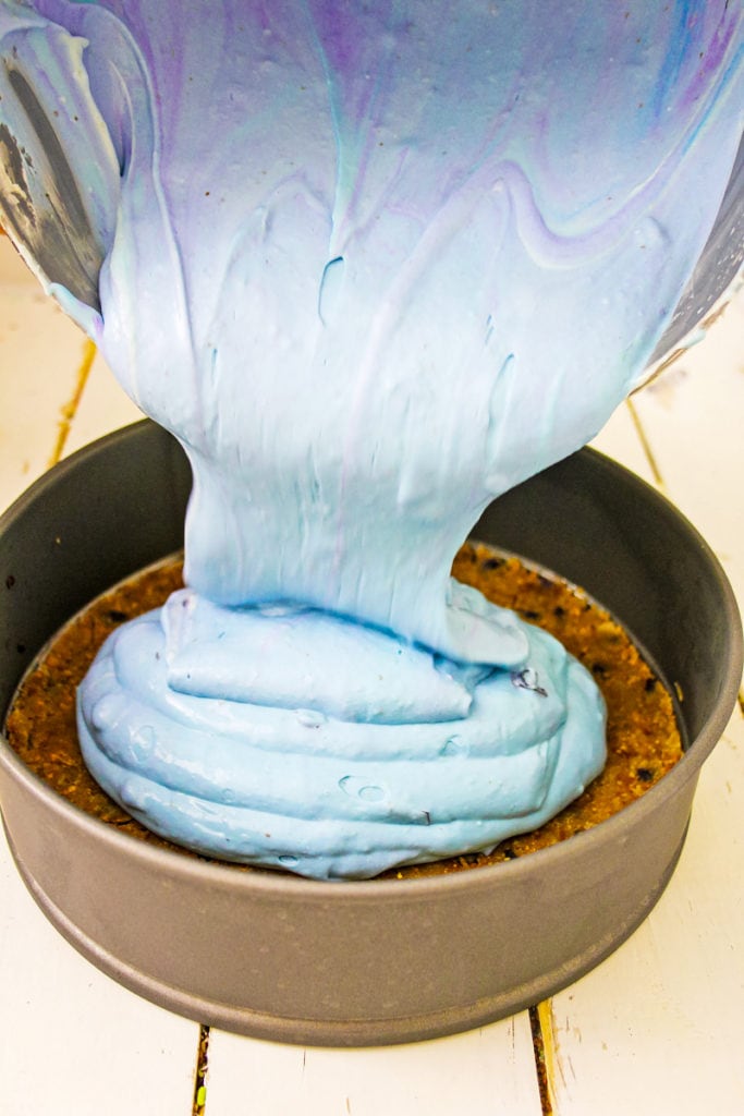 pouring the blue cheesecake batter into the springform pan