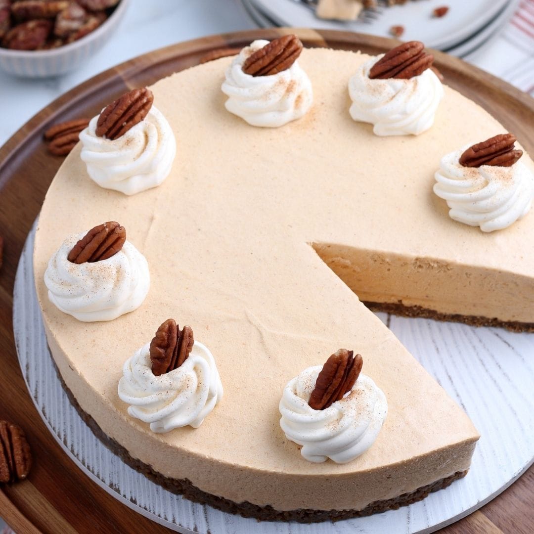 No Bake Pumpkin Cheesecake topped with whipped cream and pecans.