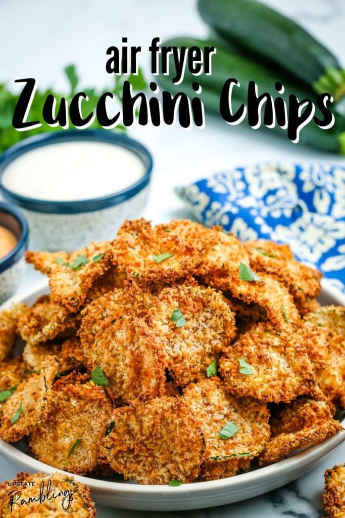 healthy zucchini chips in a bowl with dipping sauce in the background