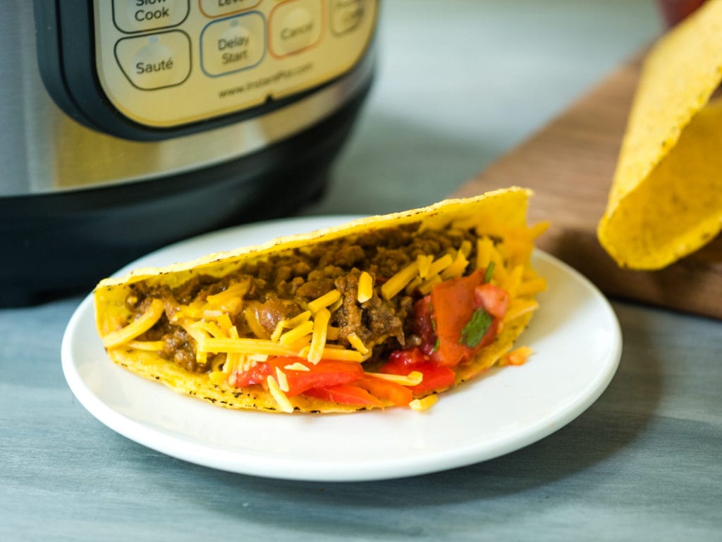filling inside a taco in front of pressure cooker