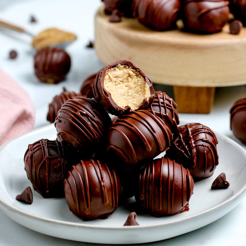 Chocolate coated peanut butter balls stacked in a pyramid.