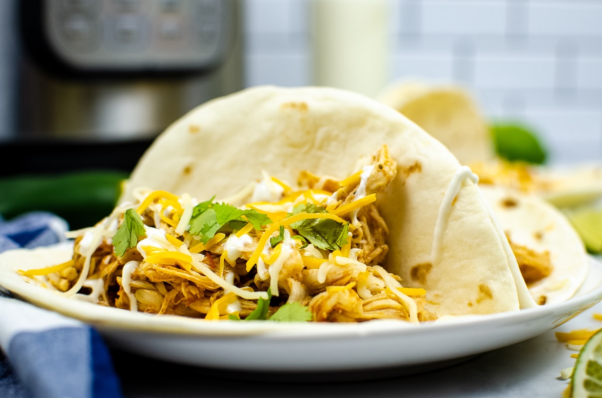 Instant pot shredded chicken tacos on a plate.